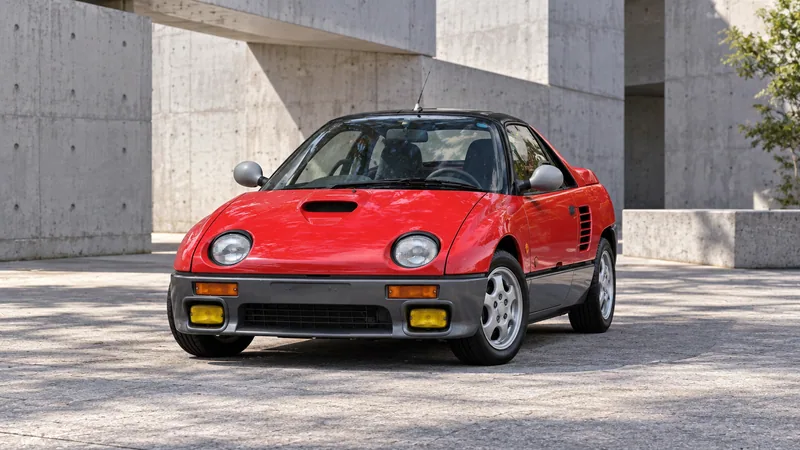 Красный Autozam AZ-1 в современном бетонном дворе
